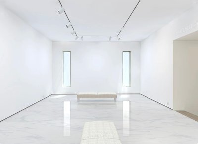 This medium sized gallery has a clean modern décor with a white marble floor. The walls are washed with a combination of spots and natural light from the three windows.