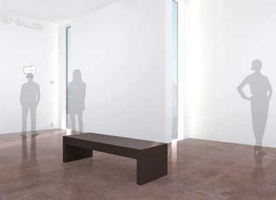 The simple architectural style of this gallery imparts scale with a minimum of fuss. It features floor to ceiling windows and a simple wooden bench on a chocolate tinted stone floor.